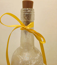 Load image into Gallery viewer, Decorative bottle with a yellow ribbon on a beige background