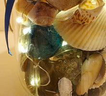 Load image into Gallery viewer, Decorative jar with seashells, glass beads, and LED lights on a beige background