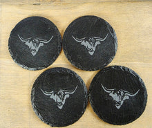 Load image into Gallery viewer, Four black coasters with cow's head design on a wooden surface