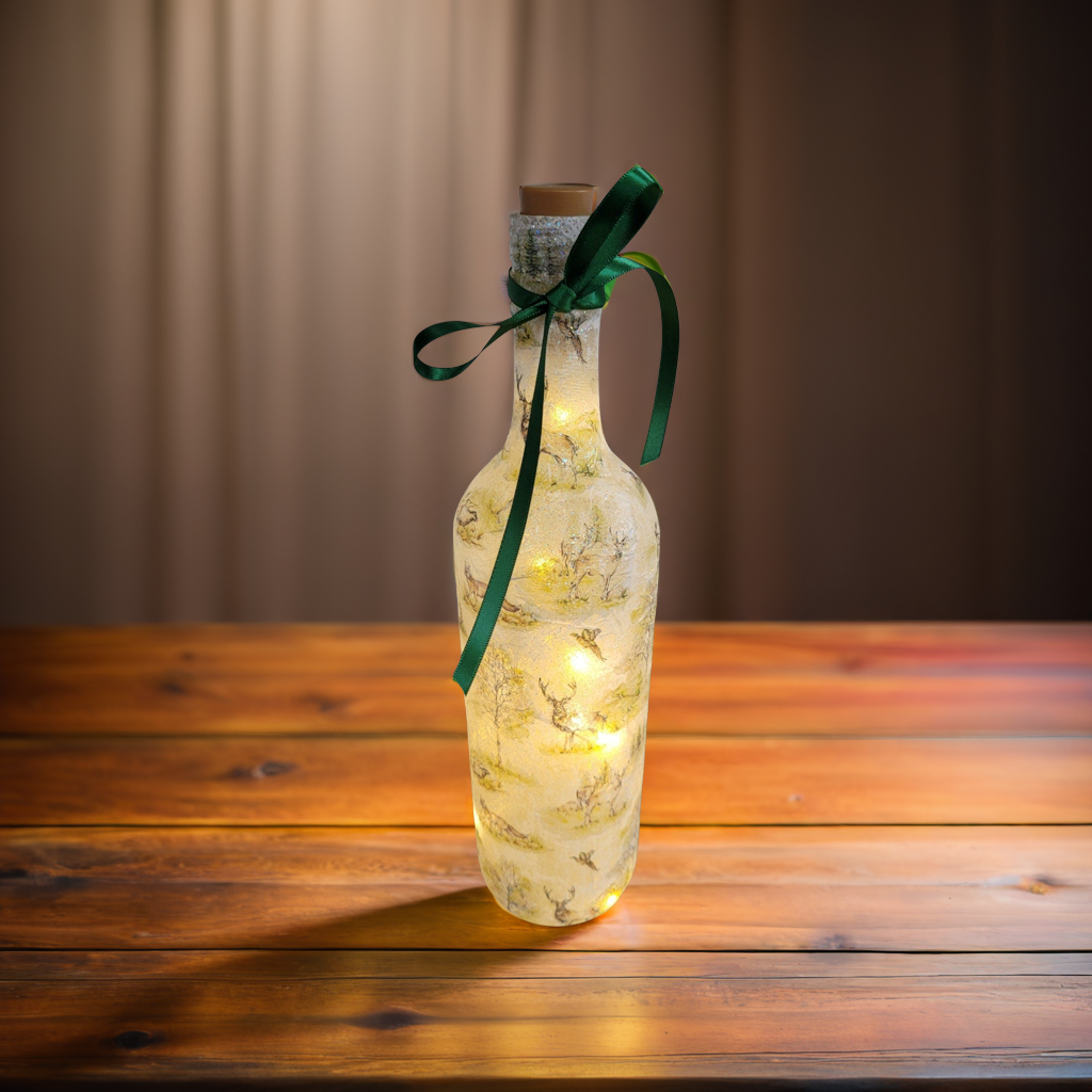 A decorated glass bottle lamp with wildlife decals, wrapped in cork, and tied with a green ribbon, standing on a wooden surface.