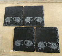 Load image into Gallery viewer, Four black slate coasters with engraved sheep designs on a wooden surface.