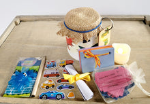Load image into Gallery viewer, White painted jar with Dinosuar detail. Hessian lid secured with a blue band, sticker sheet, blue sticky toy, lit up flameless votive candle, white rolled up note secured with yellow ribbon, key ring attached to jar with a green Dinosaur on it. Coloured card scrapbook and short brown pencil, organza bag containing pink and blue quotes