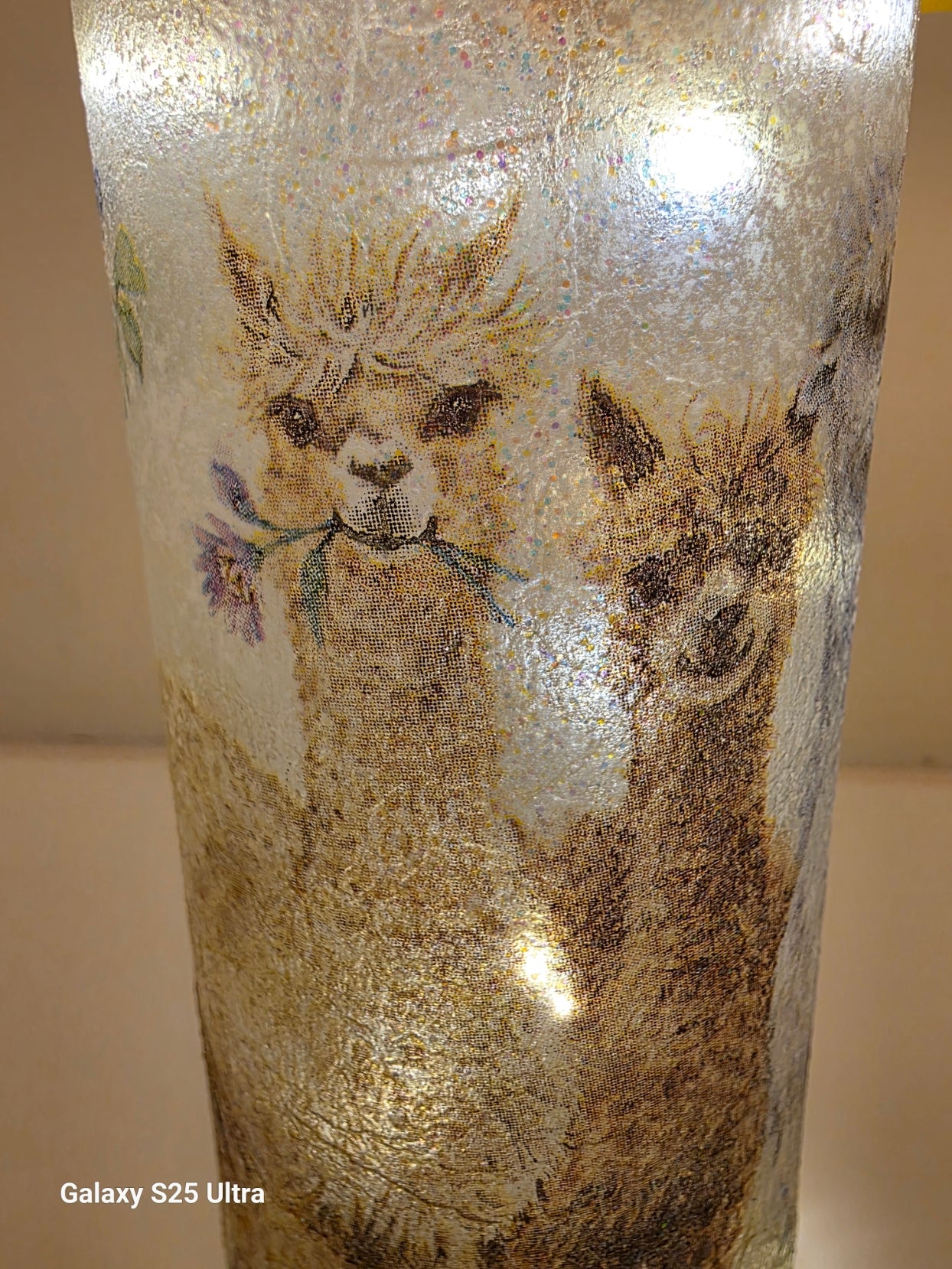 Decorative glass bottle with Alpaca design on a textured surface