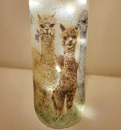 Decorative glass bottle with alpaca design on a beige background