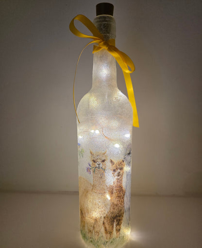 Decorative bottle with LED lights and alpaca design, tied with a yellow ribbon.