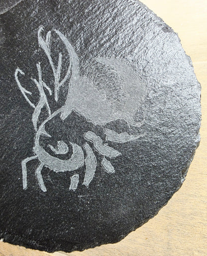 Sculpted bee design on a dark stone surface
