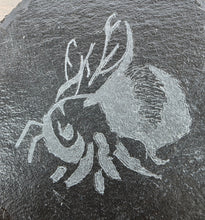 Load image into Gallery viewer, Carved design of a Bumble Bee on a dark stone surface
