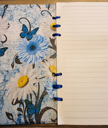 Notebook with blue floral and butterfly design on cover and lined pages