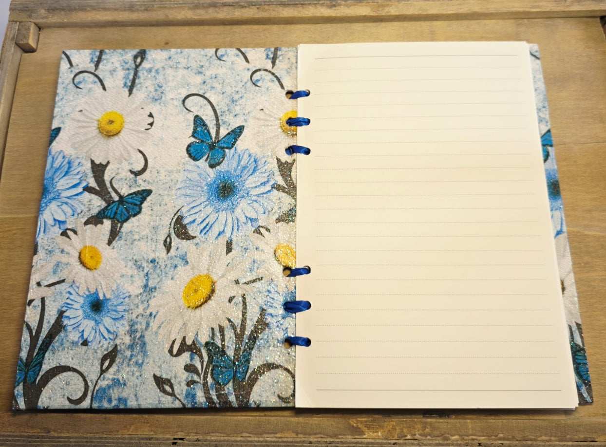 Notebook with blue floral and butterfly design on cover and lined pages