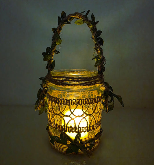 Decorative lantern with leaf-like handle and design on a plain background. Lit up with flameless candle