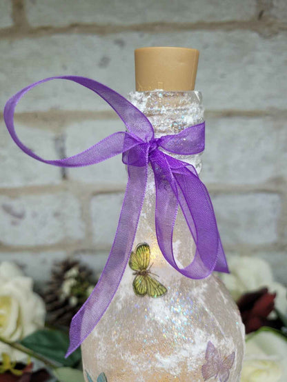 purple organza bow secured around the neck of a wine bottle with a textured surface and a butterfly