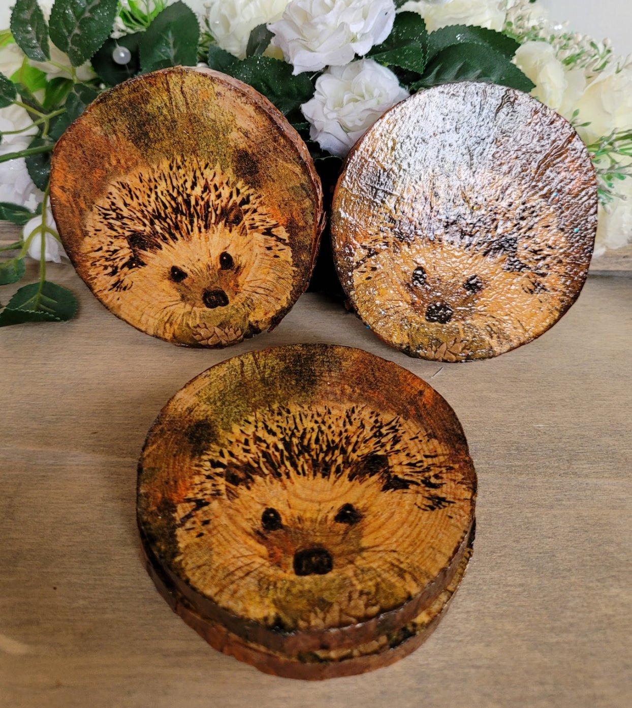 Four Decoupage Natural Wood Slice Hedgehog coasters. Varnished glossy look, hedgehog detail and bark left on the outer edge