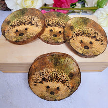 Load image into Gallery viewer, Four Decoupage Natural Wood Slice Hedgehog coasters. Varnished glossy look, hedgehog detail and bark left on the outer edge
