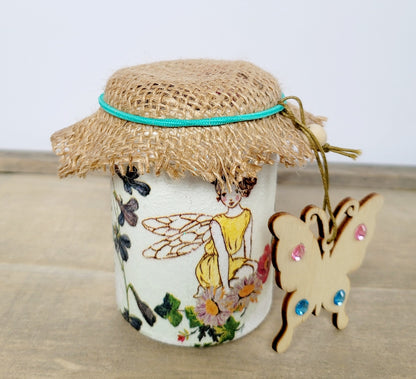 white painted jar with fairy detail. Brown hessian lid with green elastic band. Butterfly shaped wooden heart with pink and blue gems