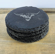 Load image into Gallery viewer, Stack of black slate coasters with a cows head design on a wooden surface
