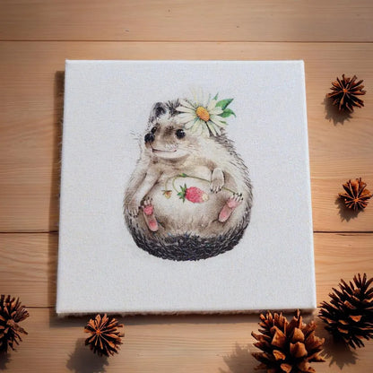 Canvas print of a hedgehog with flowers on a wooden surface with pine cones.