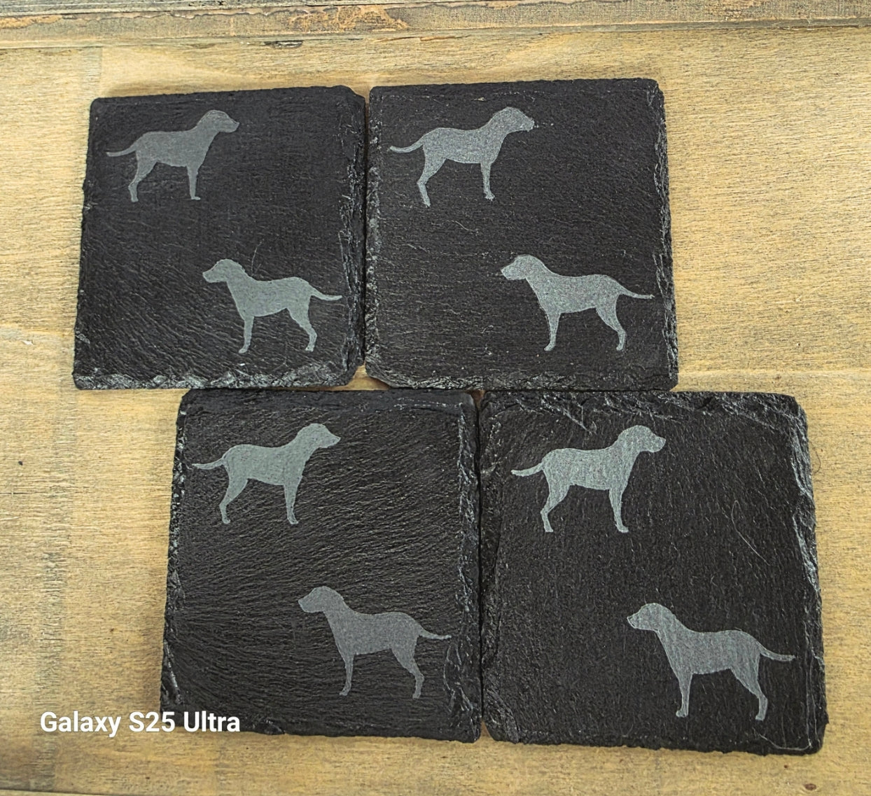 Four black slate coasters each with two labrador etched images on - dogs facing eachother