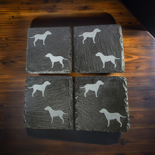 Four black slate coasters each with two labrador etched images on - dogs facing eachother