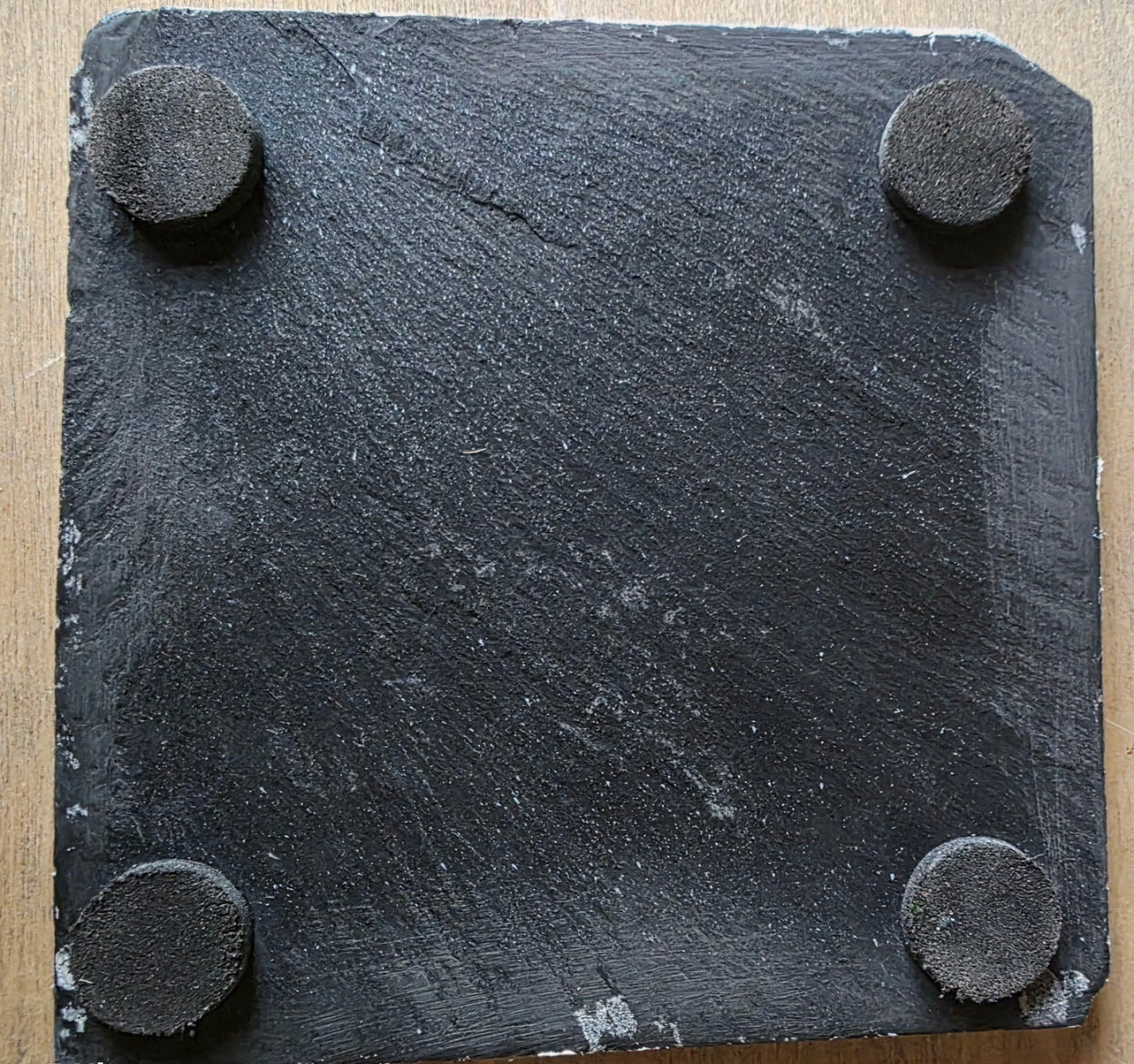 square slate coaster underside with four round protective pads