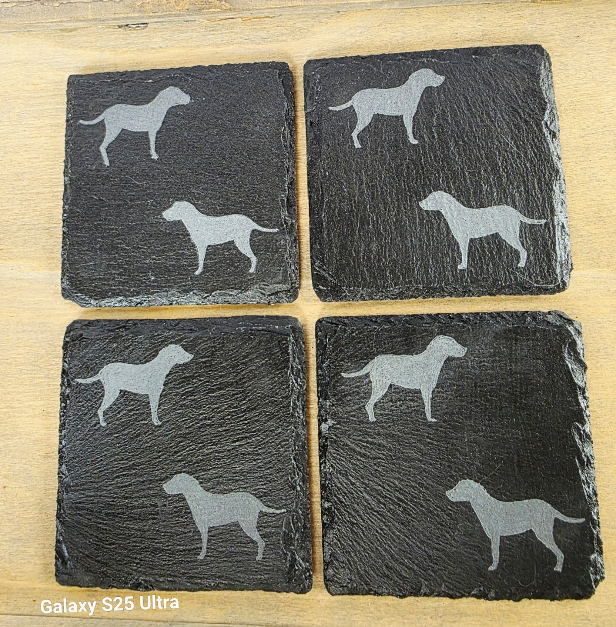 Four black slate coasters each with two labrador etched images on - dogs facing eachother