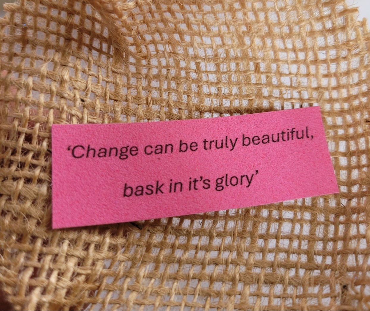 pink piece of rectangular velour paper with a quote written on 'change can be truly beautiful, bask in its glory'