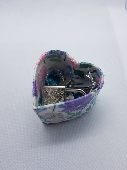Heart-shaped floral box with items inside on a white background