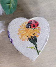 Load image into Gallery viewer, Heart-shaped decorative item with a ladybug and flower design on a wooden surface
