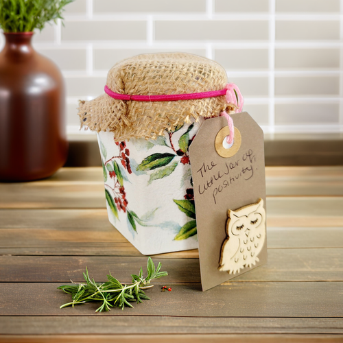 white painted jar with green leaf and red berry detail. Brown hessian lid with pink elastic band, Light brown luggage tag with owl detail 
