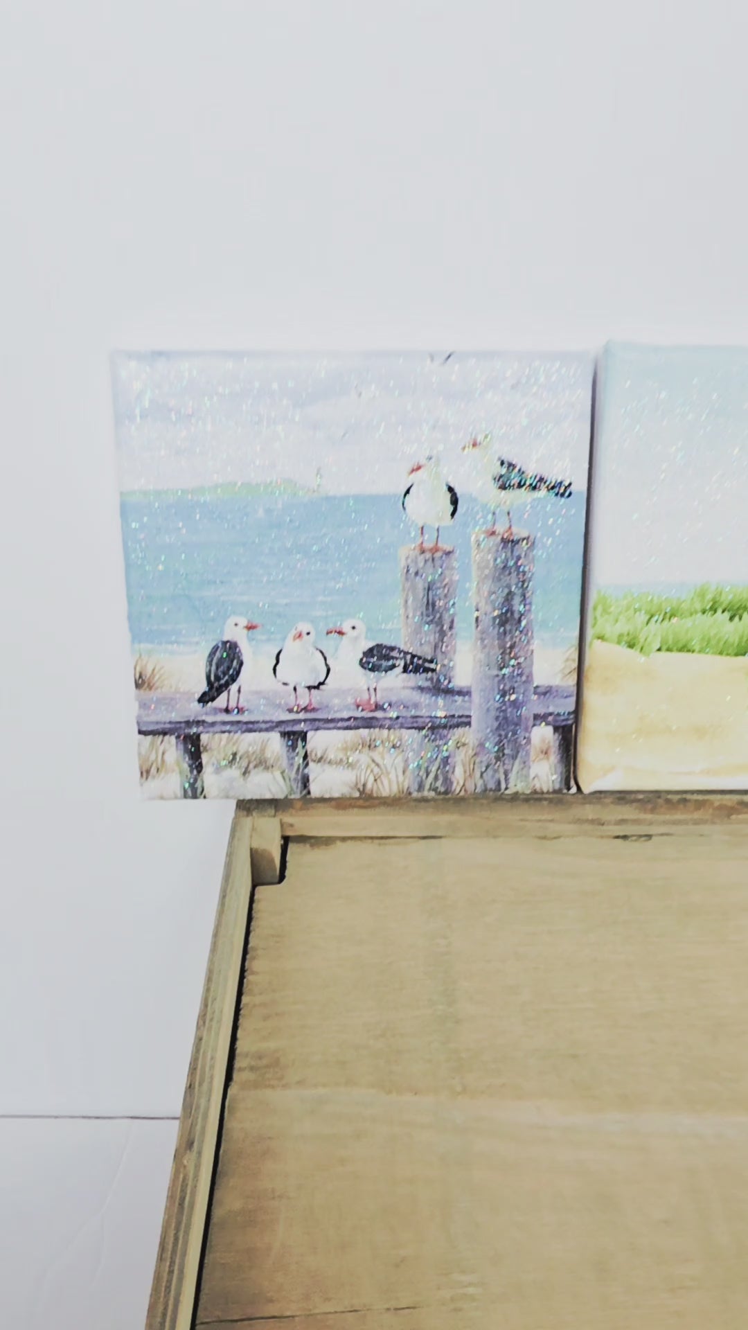 A video of three beach scene canvases - a beach hut, seagulls and a lighthouse. All images a re square