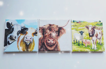 video of a set of three cow pictures on square stretched canvas. Each has different design. Decoupage technique with sparkly finish.