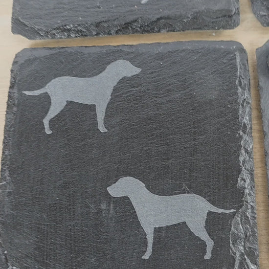 Four black slate coasters each with two labrador etched images on - dogs facing eachother