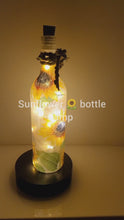 Load and play video in Gallery viewer, RLit up bottle with sunflower detail. Jute string bow with leavesotating 
