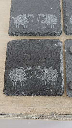 video of four slate square coasters with two sheep on each. sheep are facing eachother