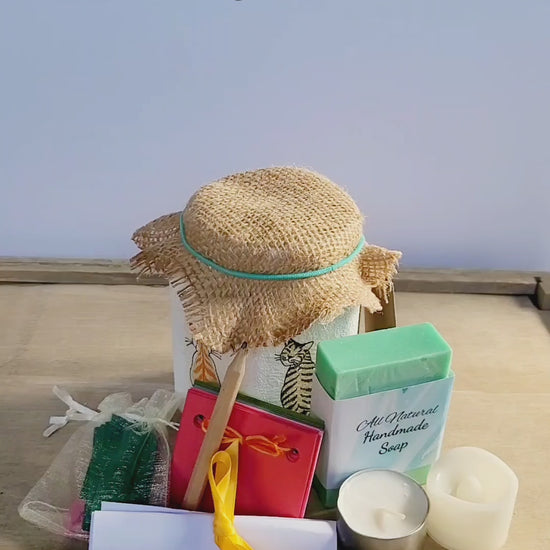 video of a white jar with a green bar of soap, tealight candle, paper scrapbook, brown pencil and small pale organza bag with green paper quotes, brown hessian lid
