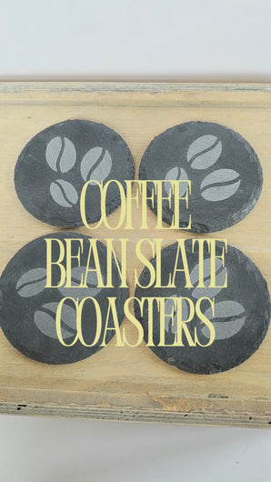 video of four black round slate coasters with coffee bean design