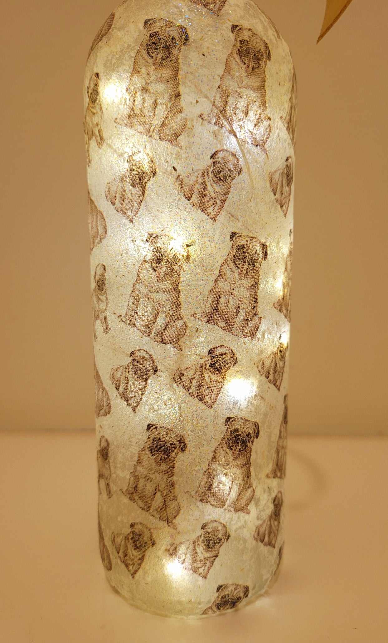 wine bottle decorated with tiny pug dog images. 