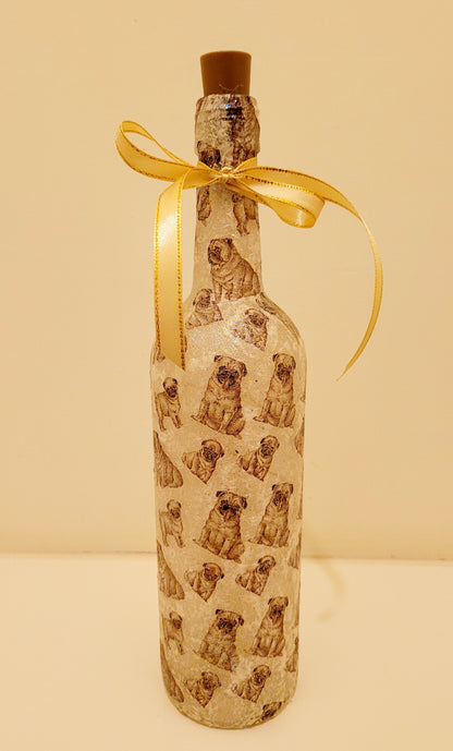 wine bottle decorated with tiny pug dog images. Cork LED lights and gold ribbon embellishment. Shown unlit