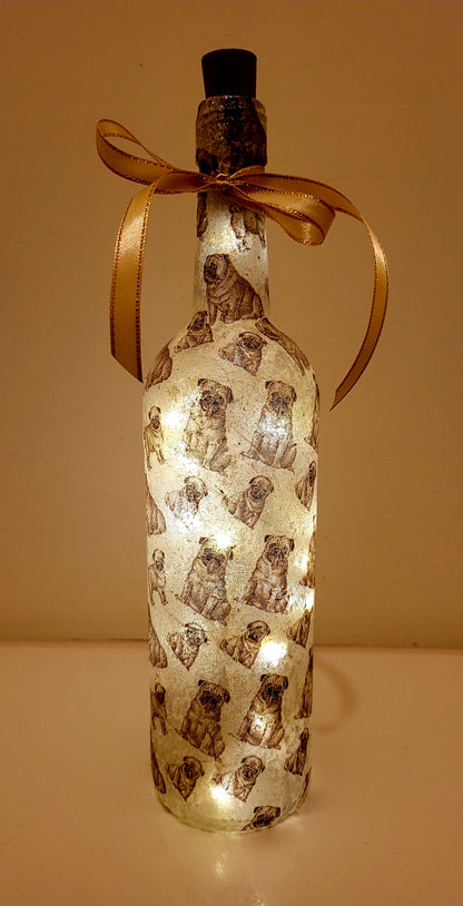 wine bottle decorated with tiny pug dog images. Cork LED lights and gold ribbon embellishment