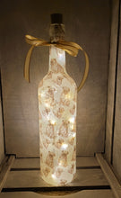 Load image into Gallery viewer, wine bottle decorated with tiny pug dog images. Cork LED lights and gold ribbon embellishment
