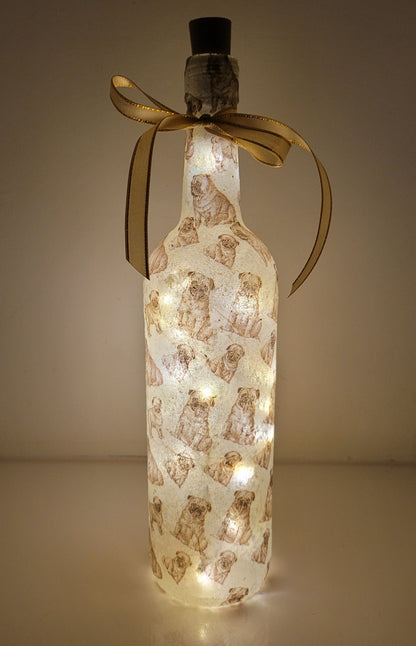 wine bottle decorated with tiny pug dog images. Cork LED lights and gold ribbon embellishment