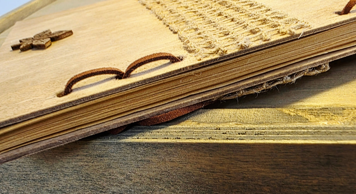 Close-up of a wooden journal spine - suede leather string bound on a wooden surface. Pages showing on the spine