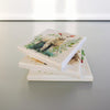 Three square canvas art pieces stacked. Each canvas features a different decoupage wildlife illustration. The top canvas shows a lamb surrounded by greenery. The other canvases have nature-themed illustrations.