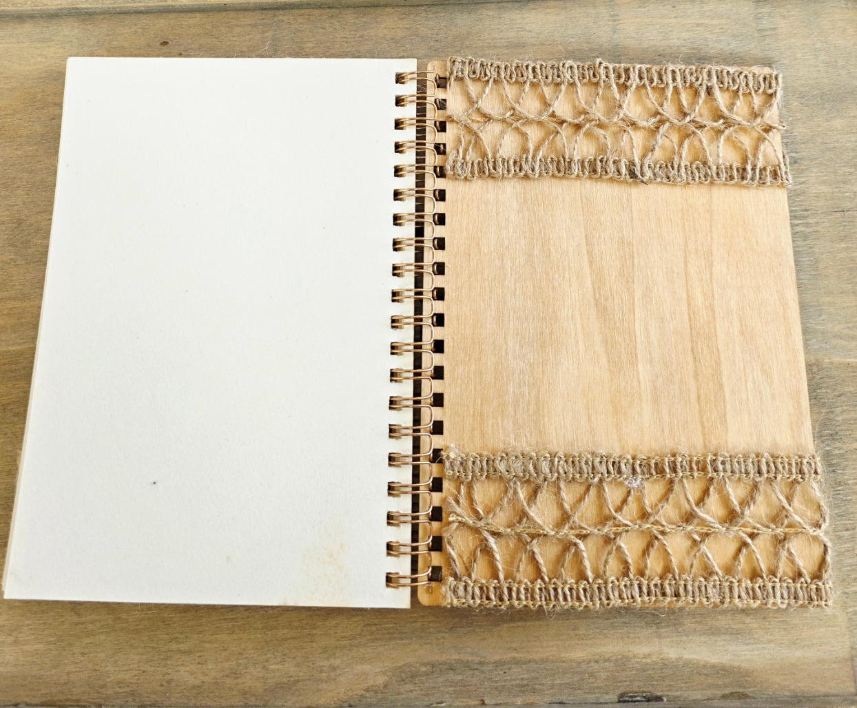 Wooden notebook with burlap decoration on the back inside cover. Plain pages. Metal spiral bound edge