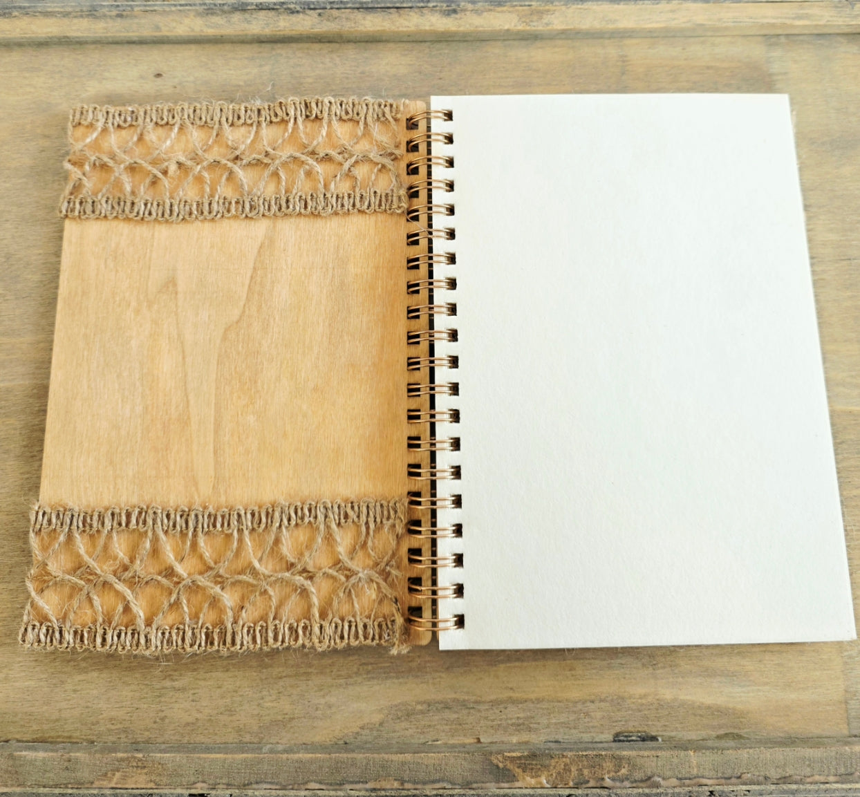 Open wooden notebook with a decorative inside cover of burlap decoration top and bottom. Plain pages 