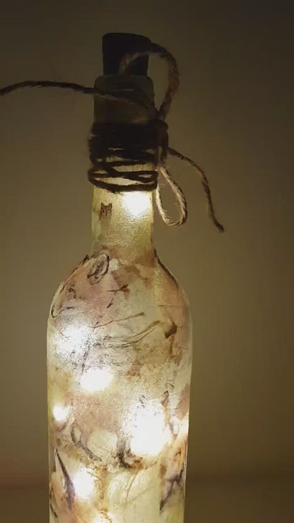 Rotating example of a lit up wine bottle with fox detailing and cork LED lights. Jute string bow
