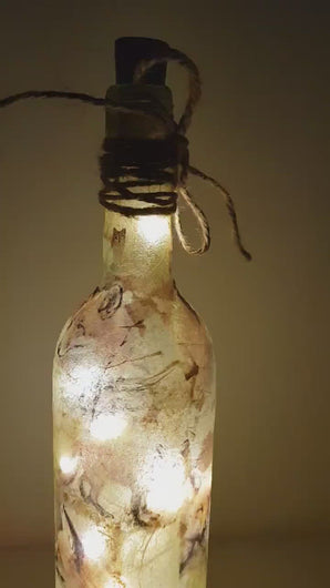 Rotating example of a lit up wine bottle with fox detailing and cork LED lights. Jute string bow