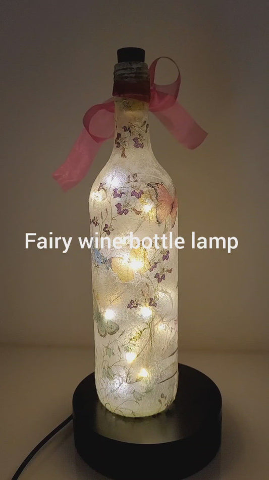 Rotating example of a Lit up wine bottle with Fairy and flower design. Pink bow.