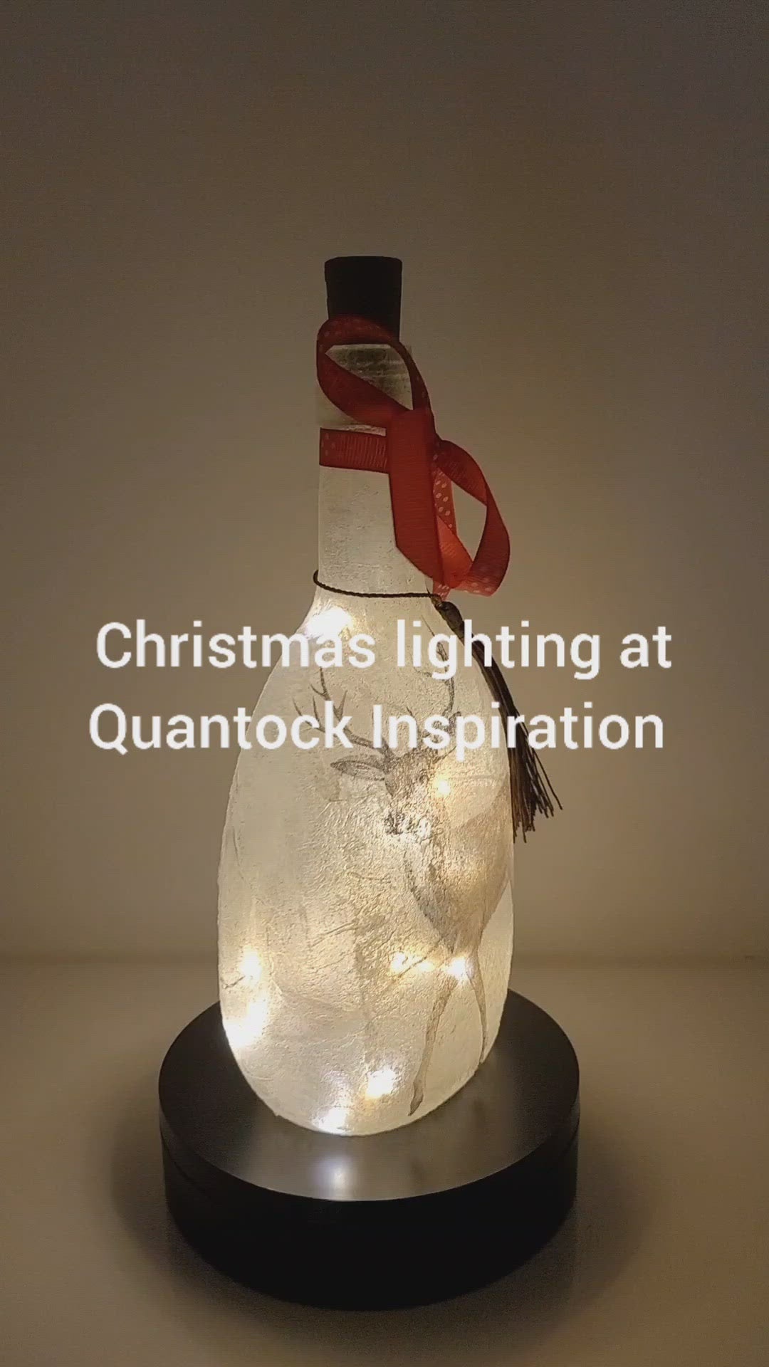 Rotating example of a Lit up round bottle with Stag detail. Cork LED lights, red bow.
