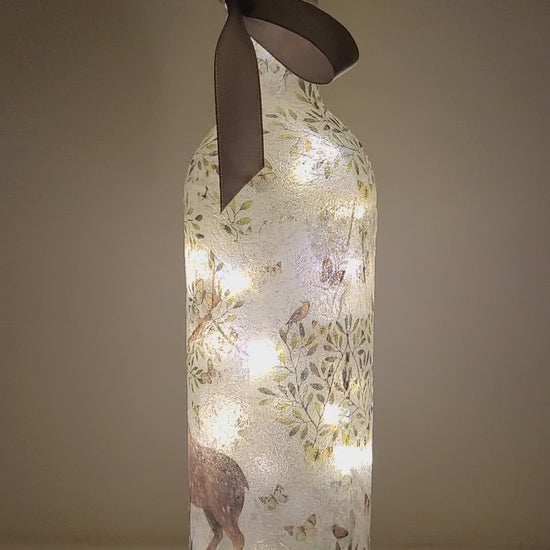 Rotating lit up wine bottle with Stag and leaf detail. Grey bow finish