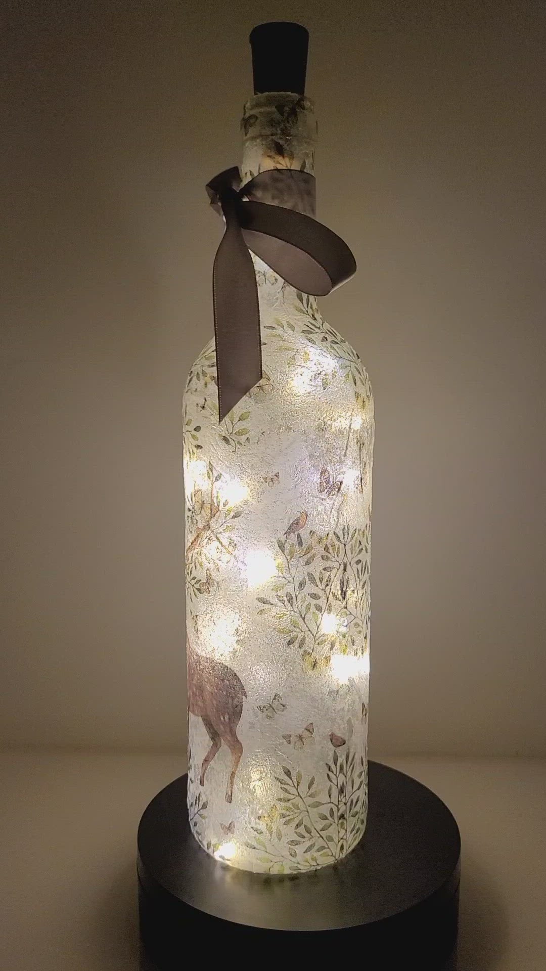 Rotating lit up wine bottle with Stag and leaf detail. Grey bow finish